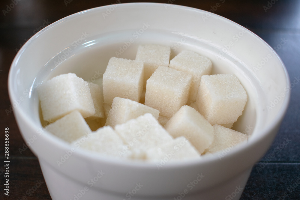 Refined sugar cubes in a sugar bowl. Refined sugar cubes in a sugar bowl.
