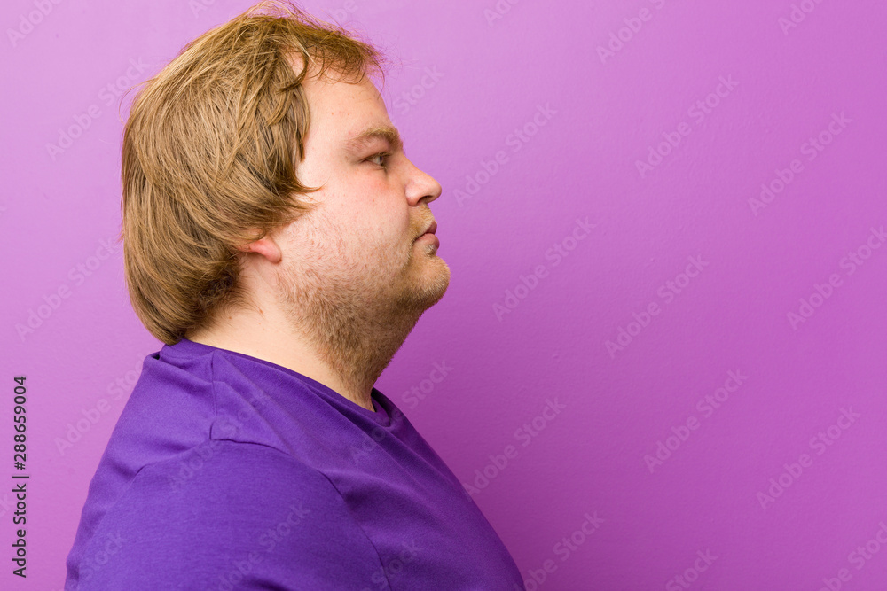 Fototapeta premium Young authentic redhead fat man gazing left, sideways pose.