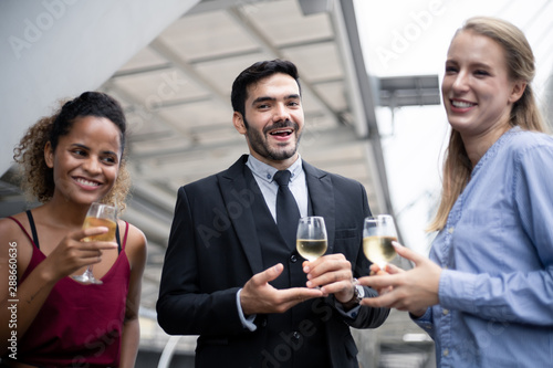 Group of business people celebrate by drinking wine.