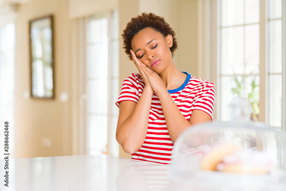 Young beautiful african american woman at home sleeping tired dreaming and posing with hands together while smiling with closed eyes. Young beautiful african american woman at home sleeping tired dreaming and posing with hands together while smiling with closed eyes.
