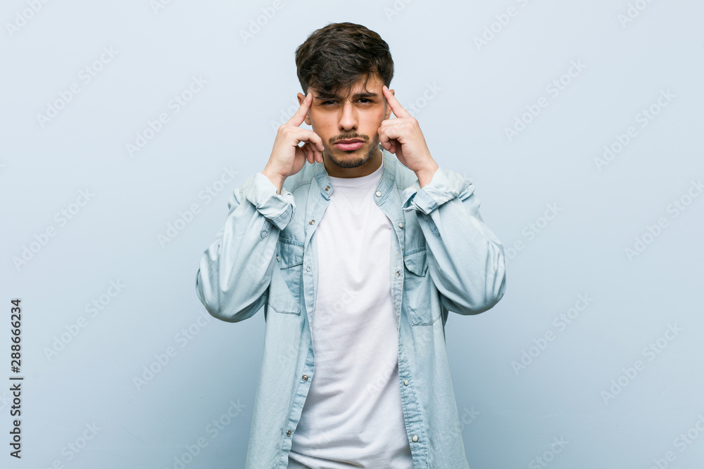 Young hispanic cool man focused on a task, keeping forefingers pointing head. Young hispanic cool man focused on a task, keeping forefingers pointing head.