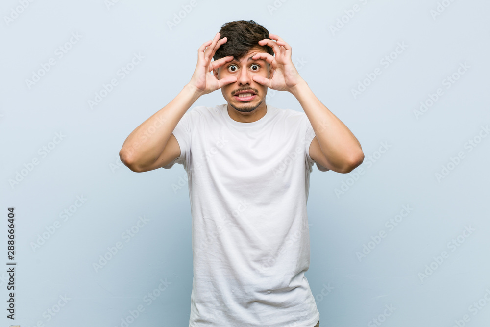 Young caucasian man wearing a white tshirt keeping eyes opened to find a success opportunity. Young caucasian man wearing a white tshirt keeping eyes opened to find a success opportunity.
