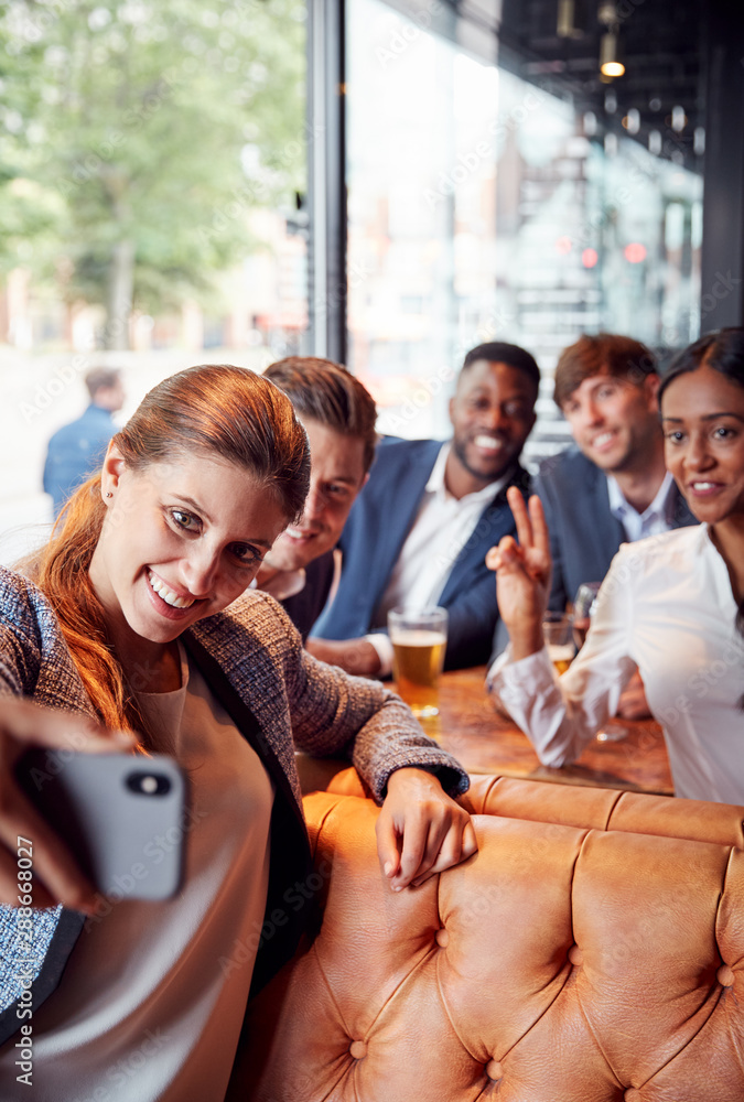 Obraz premium Group Of Business Colleagues Posing For Selfie In Bar After Work