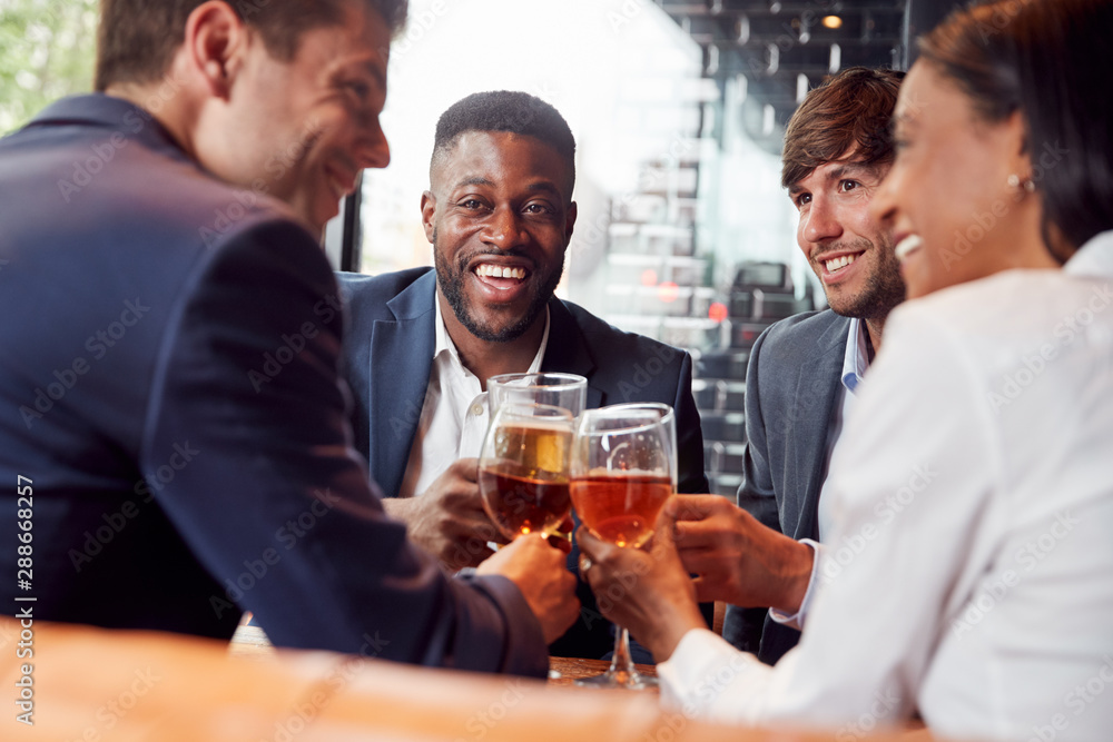 Group Of Business Colleagues Making A Toast As They Meet For Drinks And Socialize In Bar After Work