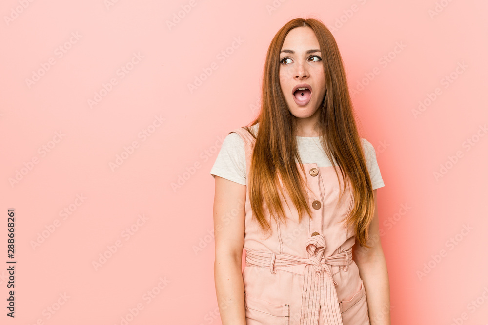 Young ginger woman with freckles being shocked because of something she has seen. Young ginger woman with freckles being shocked because of something she has seen.