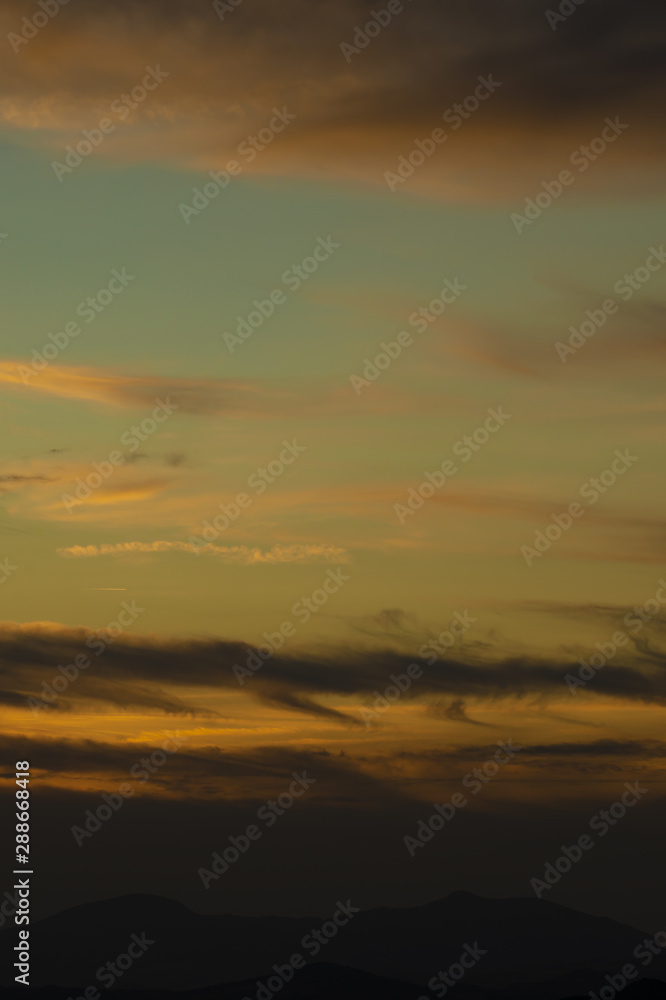 Golden sky with white cotton clouds
