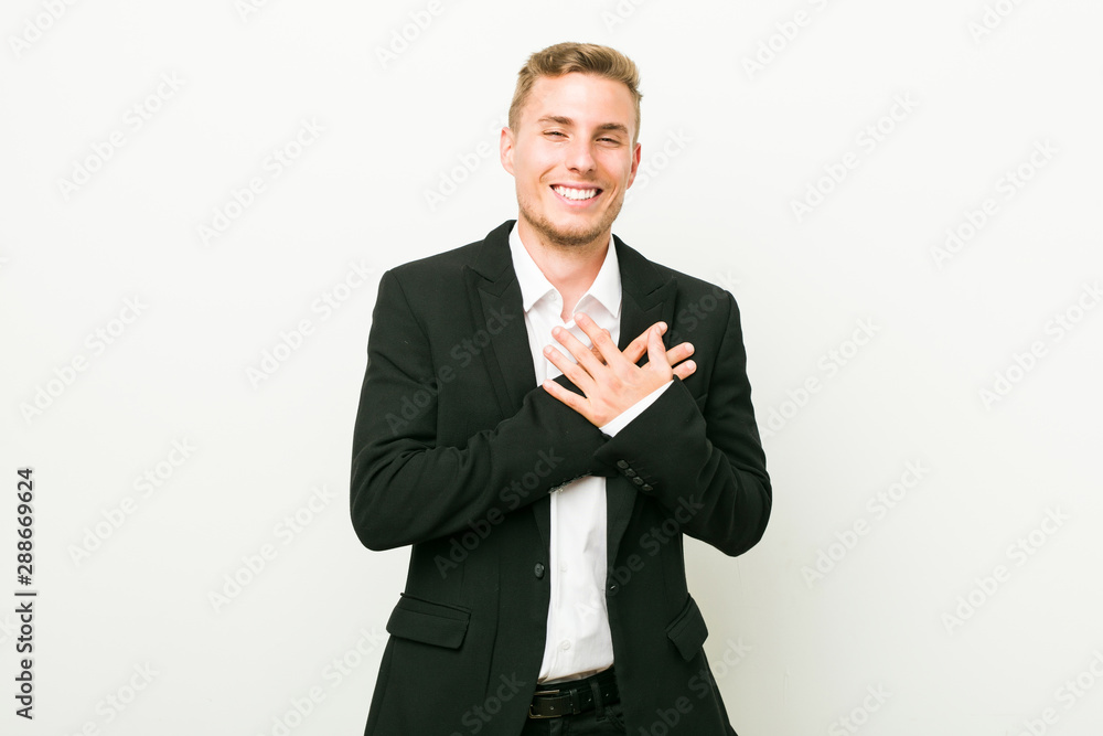 Young caucasian business man laughing keeping hands on heart, concept of happiness. Young caucasian business man laughing keeping hands on heart, concept of happiness.