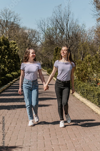 Friendship day. Lifestyle image of best friend girls in spring summer city street. Two Teenage girls having fun in the park