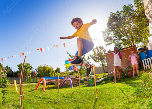 Papier peint Boy jump over strings passing course of obstacles