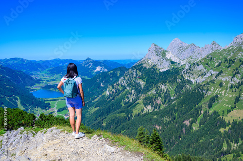 Hiker at Tannheim valley with view on the lake Haldensee from the mountain Neunerköpfle - Hiking in beautiful landscape scneery of Alps, Tirol, Austria, Europe