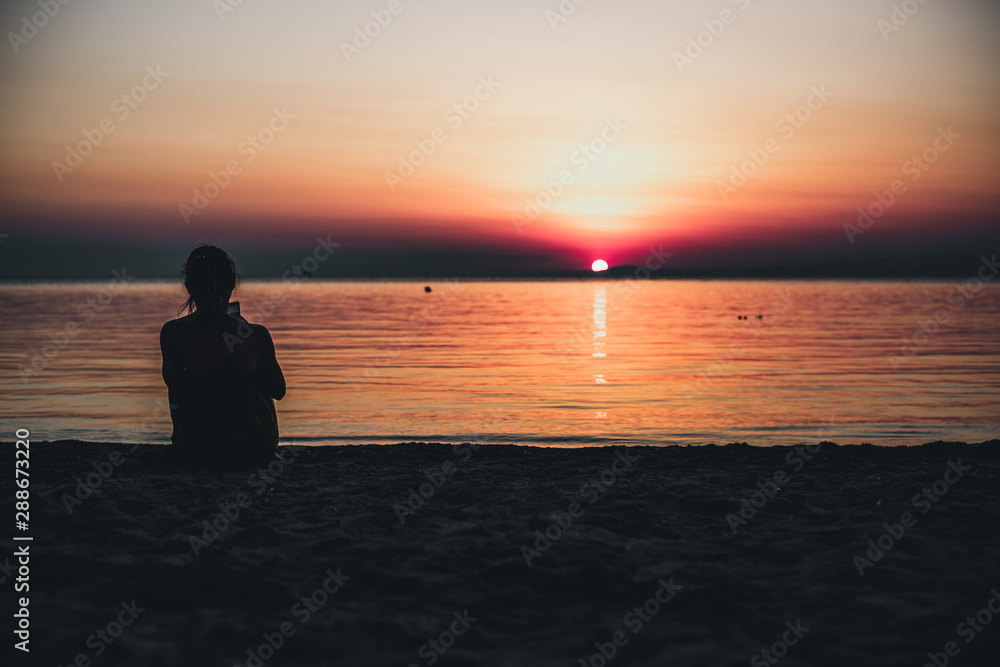 Woman tourist looking at sunset at sea, holidays in Greece, Halkidiki