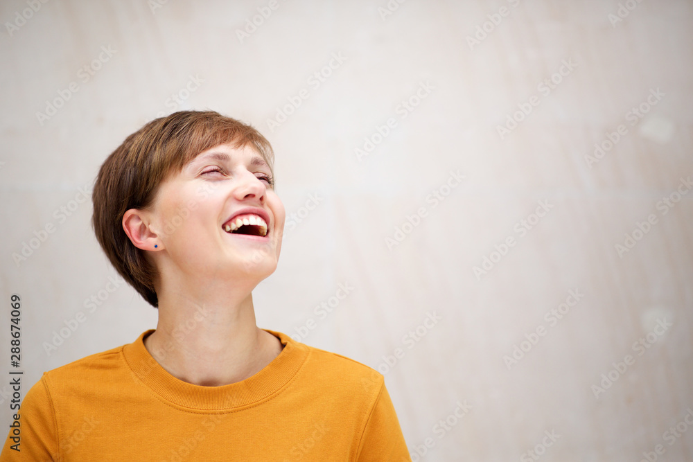 Close up laughing young woman looking away Close up laughing young woman looking away