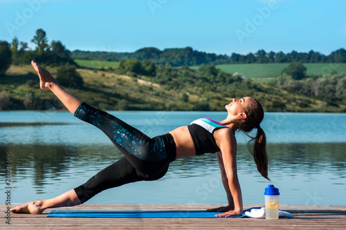 Beautiful girl practices yoga on the background of beautiful nature. Pilates. Healthy lifestyle concept