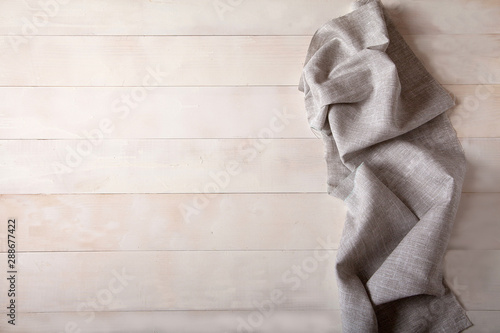 Gray linen napkin on a white wooden background. Flat lay.