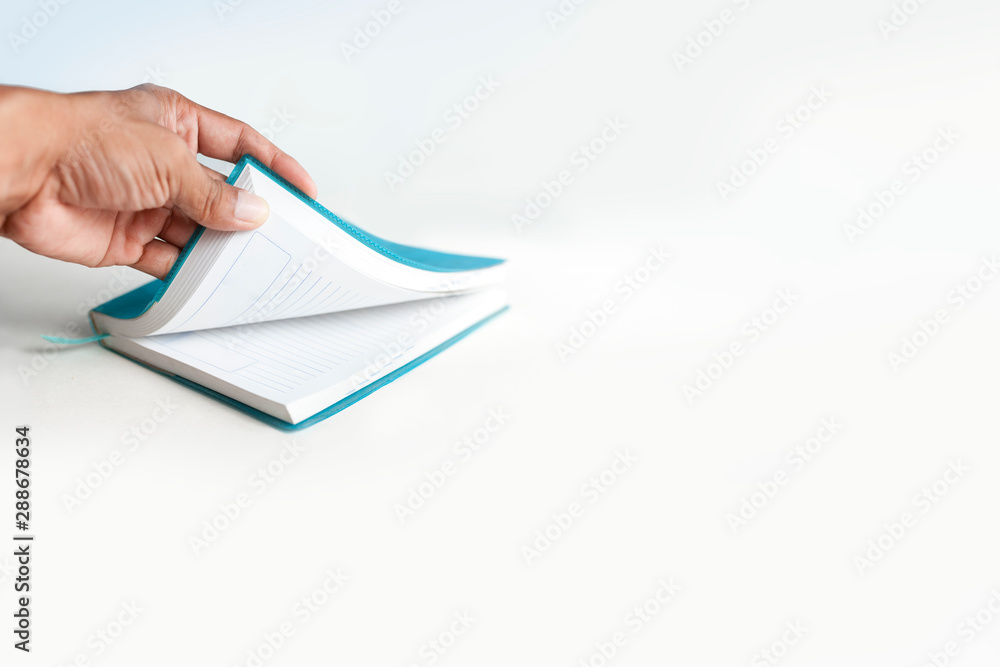 left hand is opening notebook in a white background left hand is opening notebook in a white background