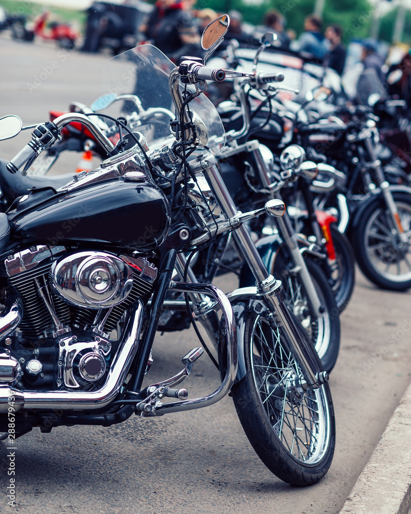 Lots of mopeds and motorbikes parked on the street.