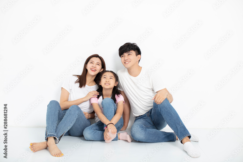 Happy Young family Sitting On Floor Looking Up Happy Young family Sitting On Floor Looking Up