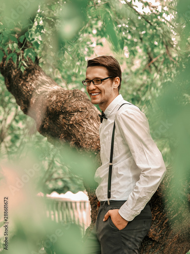 happy fianc standing among the trees in the spring garden. photo