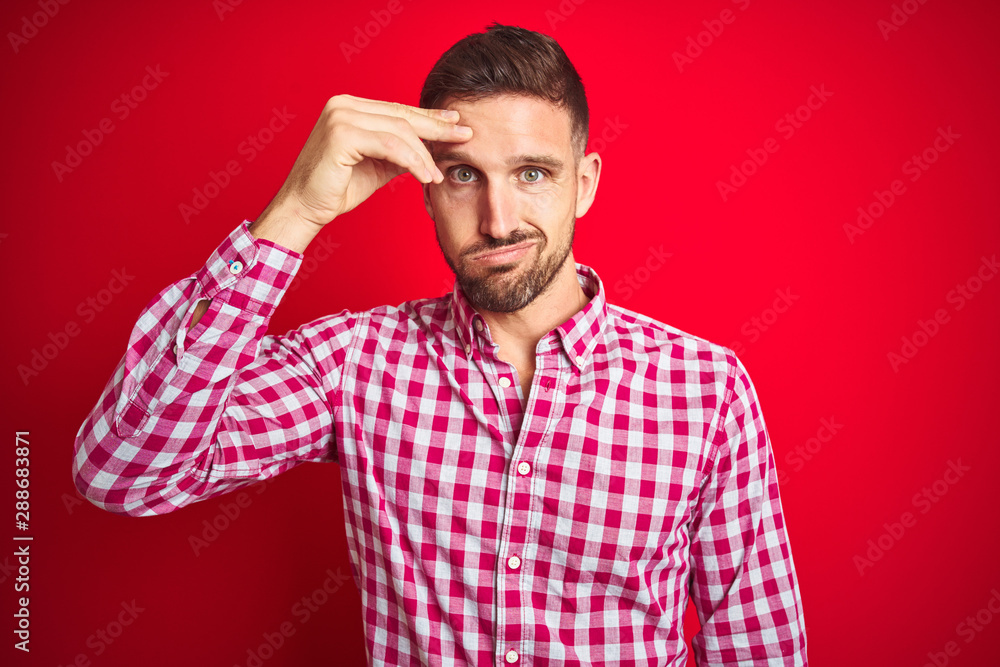 Young handsome man over red isolated background worried and stressed about a problem with hand on forehead, nervous and anxious for crisis Young handsome man over red isolated background worried and stressed about a problem with hand on forehead, nervous and anxious for crisis