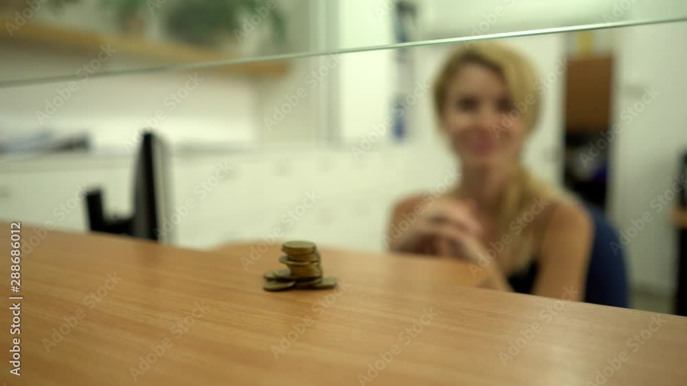 The client, customer in a bank invests, pays, gives coins the cashier Folds in a column. The client, customer in a bank invests, pays, gives coins the cashier Folds in a column.