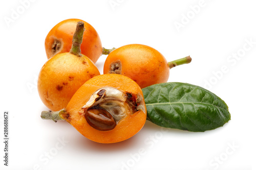 Half and whole ripe loquat fruits with leaf isolated on white background