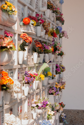 Plastic fake flowers in front of a cemetery niches