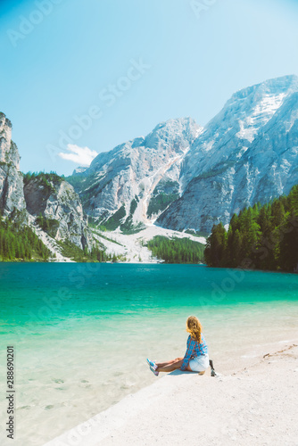 woman sitting on the beach of mountain lake summer season