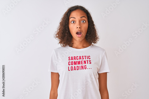 Brazilian woman wearing fanny t-shirt with irony comments over isolated white background scared in shock with a surprise face, afraid and excited with fear expression photo