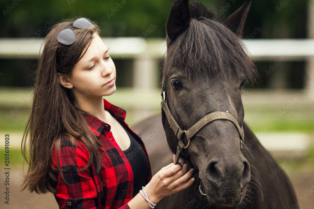 Obraz premium Young girl with the black horse