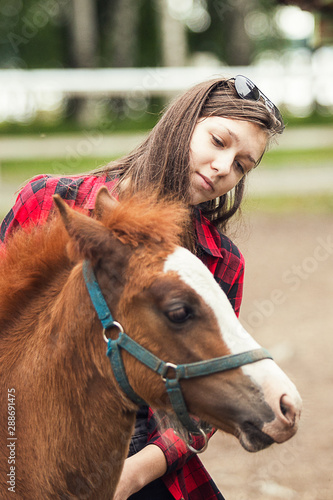 Young girl with the brown foal