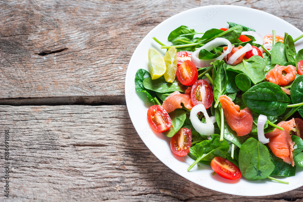 Selective focus Salmon Fresh green Salad with spinach, cherry tomatoes,baby spinach, Concept for a tasty and healthy meal. Dark stone background. Top view. Close up. Selective focus Salmon Fresh green Salad with spinach, cherry tomatoes,baby spinach, Concept for a tasty and healthy meal. Dark stone background. Top view. Close up.