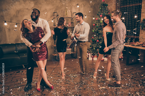 Full length photo of charming couple dance and fellows play sing in karaoke enjoy christmas party x-mas holidays in house indoors