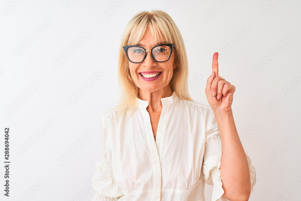 Middle age businesswoman wearing shirt and glasses standing over isolated white background surprised with an idea or question pointing finger with happy face, number one