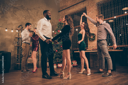 Full size low angle photo of charming lovers dance hold hands spinning celebrate christmas on x-mas party in house with newyear decoration indoors