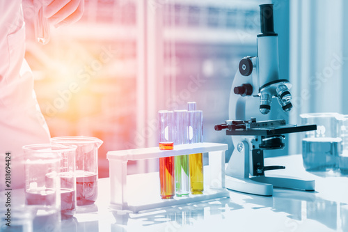 Scientists put liquid in beakers and chemical test tubes in a science lab laboratory. About doing research for science concept