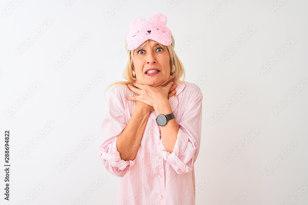 Middle age woman wearing sleep mask and pajama over isolated white background shouting and suffocate because painful strangle. Health problem. Asphyxiate and suicide concept. Middle age woman wearing sleep mask and pajama over isolated white background shouting and suffocate because painful strangle. Health problem. Asphyxiate and suicide concept.