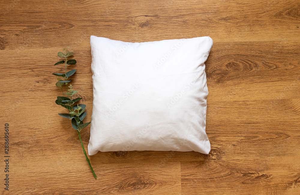 © StaCheck Photography - Blank pillow mockup on wooden floor background and eucalyptus plant prop