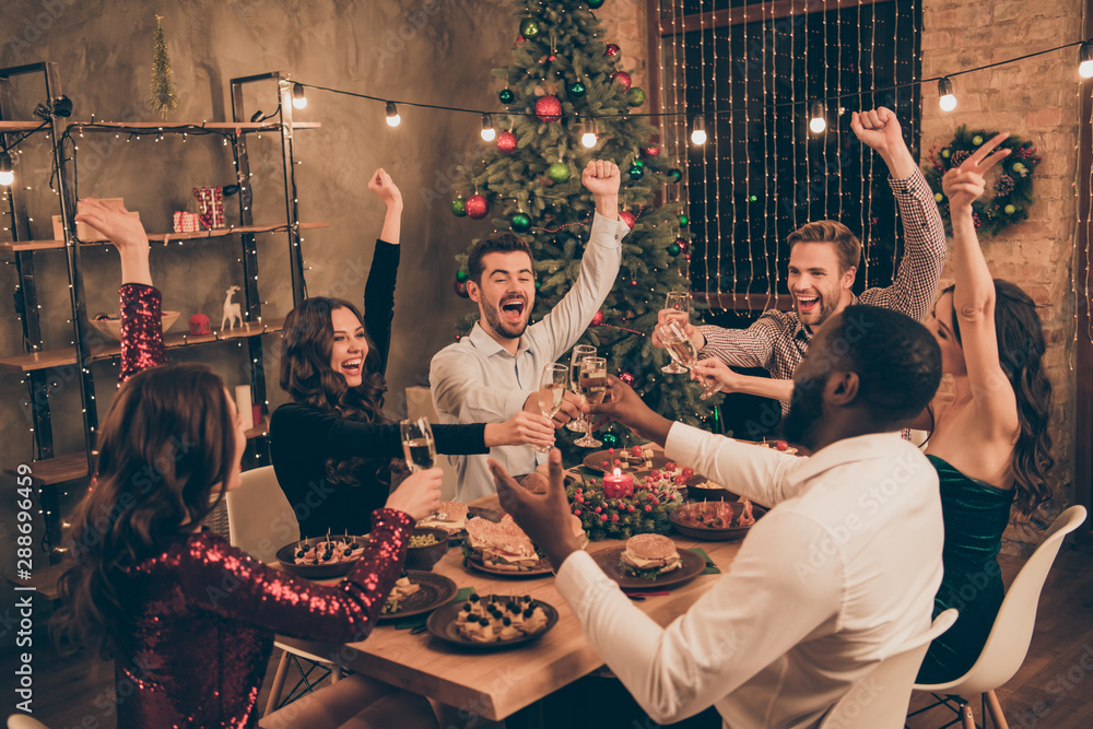 Fototapeta premium Portrait of nice attractive gorgeous smart stylish cheerful cheery ecstatic excited glad positive guys having fun congratulating midnight dream wish rising hands up in decorated house room