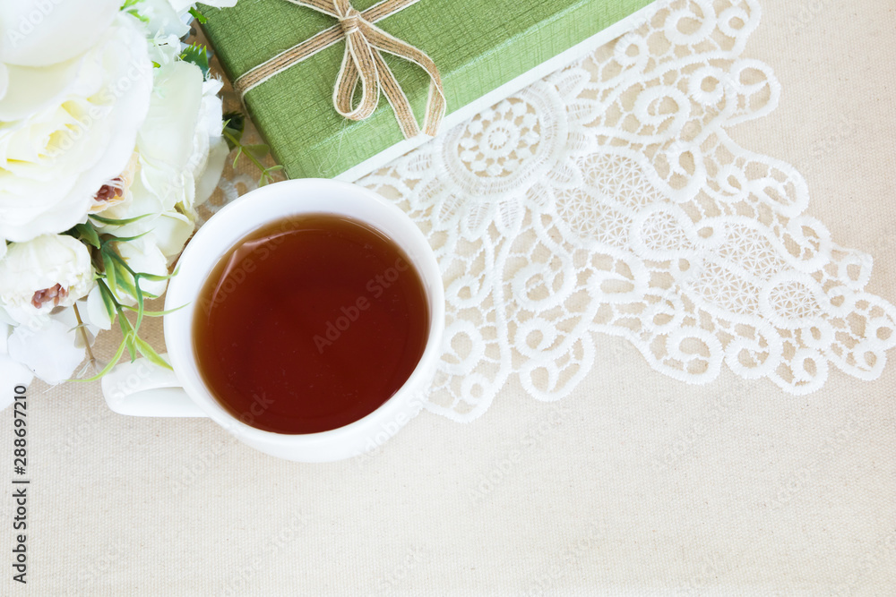 Beautiful top view flat lay a cup of tea with lace decorations flower bouquet and green gift box for wedding background or valentines concept Beautiful top view flat lay a cup of tea with lace decorations flower bouquet and green gift box for wedding background or valentines concept