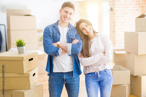 Beautiful young couple moving to a new house happy face smiling with crossed arms looking at the camera. Positive person. © Krakenimages.com