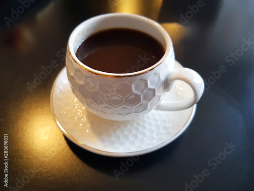 espresso coffee in white cap on black table