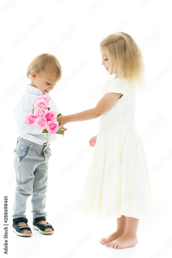A little boy gives a girl a bouquet of flowers. The concept of l A little boy gives a girl a bouquet of flowers. The concept of l