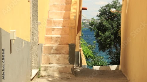 Small road in the village of Procida, near Naples. Houses painted in ocher yellow.