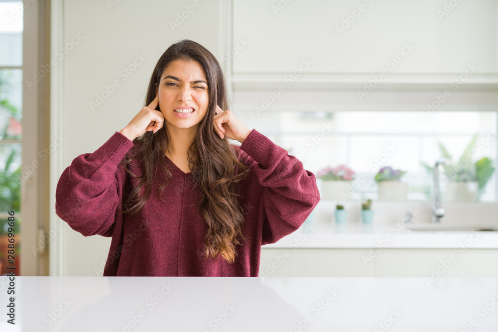 Young beautiful woman at home covering ears with fingers with annoyed expression for the noise of loud music. Deaf concept. Young beautiful woman at home covering ears with fingers with annoyed expression for the noise of loud music. Deaf concept.