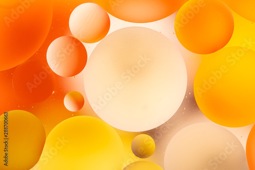 bright oily drops in water with colorful background, close-up 