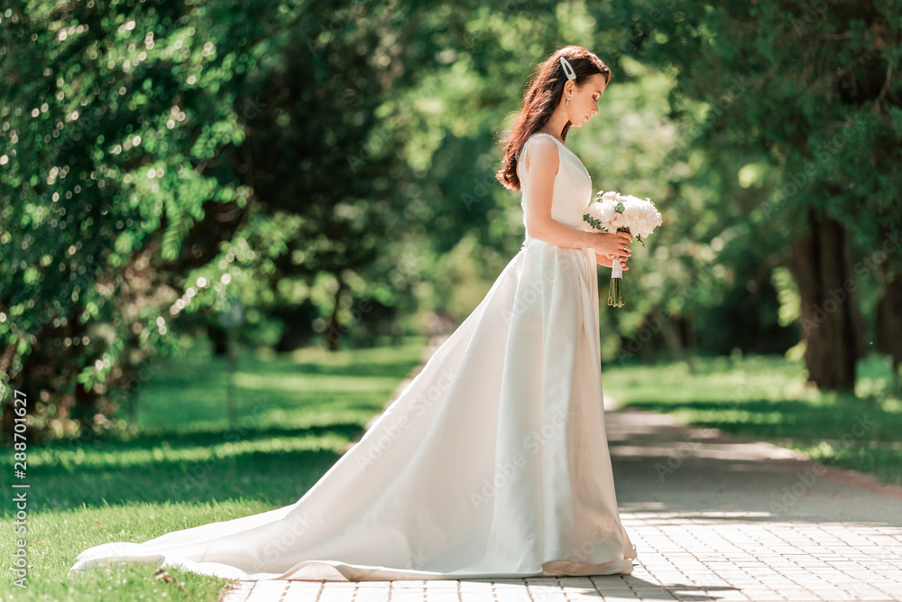 beautiful young woman in wedding dress standing in Park.