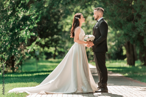 loving couple of newlyweds standing on a Park alley