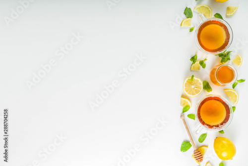 Autumn tea with mint and lemon with ingredient-s - fresh mint leaves, sliced lemon and honey, white background copy space 