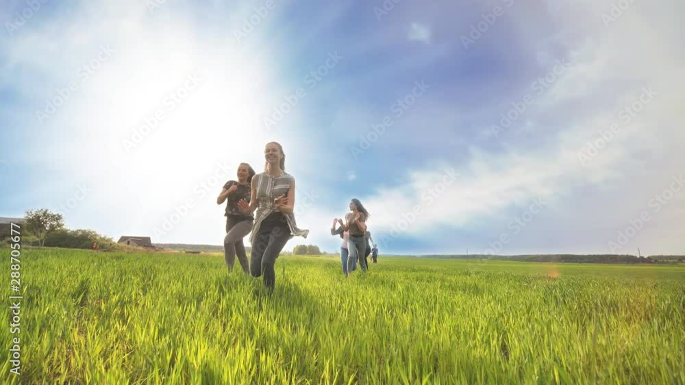 Happy friends run against the backdrop of a beautiful sky and sun. Happy friends run against the backdrop of a beautiful sky and sun.