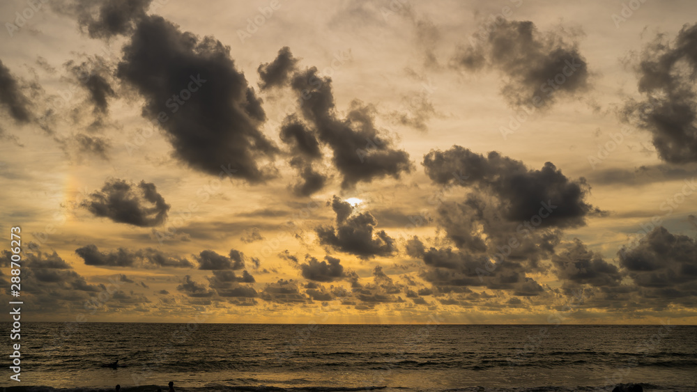 Obraz premium A of the large dark tone sunset as the massive sun sets into the horizon above the ocean, Sunset sky clouds. Sunset sky background. Sunset sky orange blue.at Phuket Thailand.;